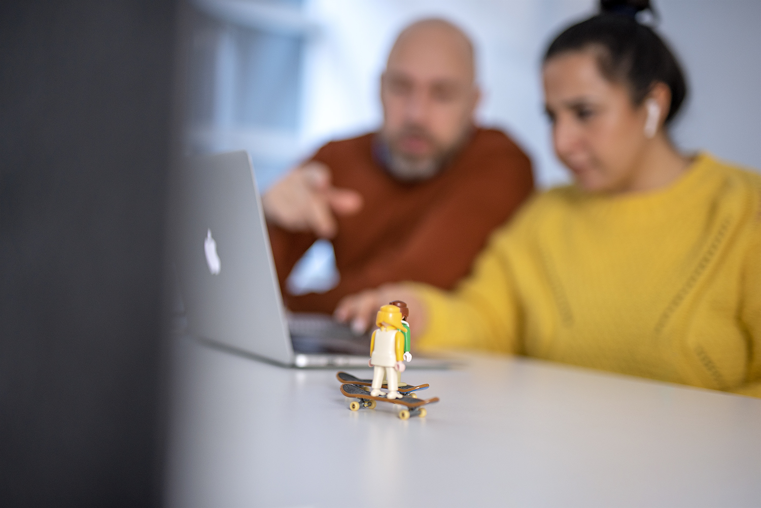 Image of 2 team members in front of a laptop